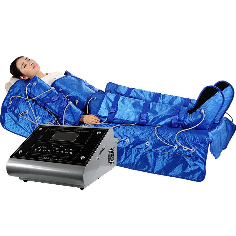 Person wearing a blue full-body pressotherapy compression suit connected by tubes to a professional control unit.